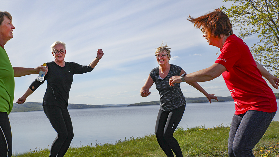 Kvinnor som tränar i grupp vid en sjö.